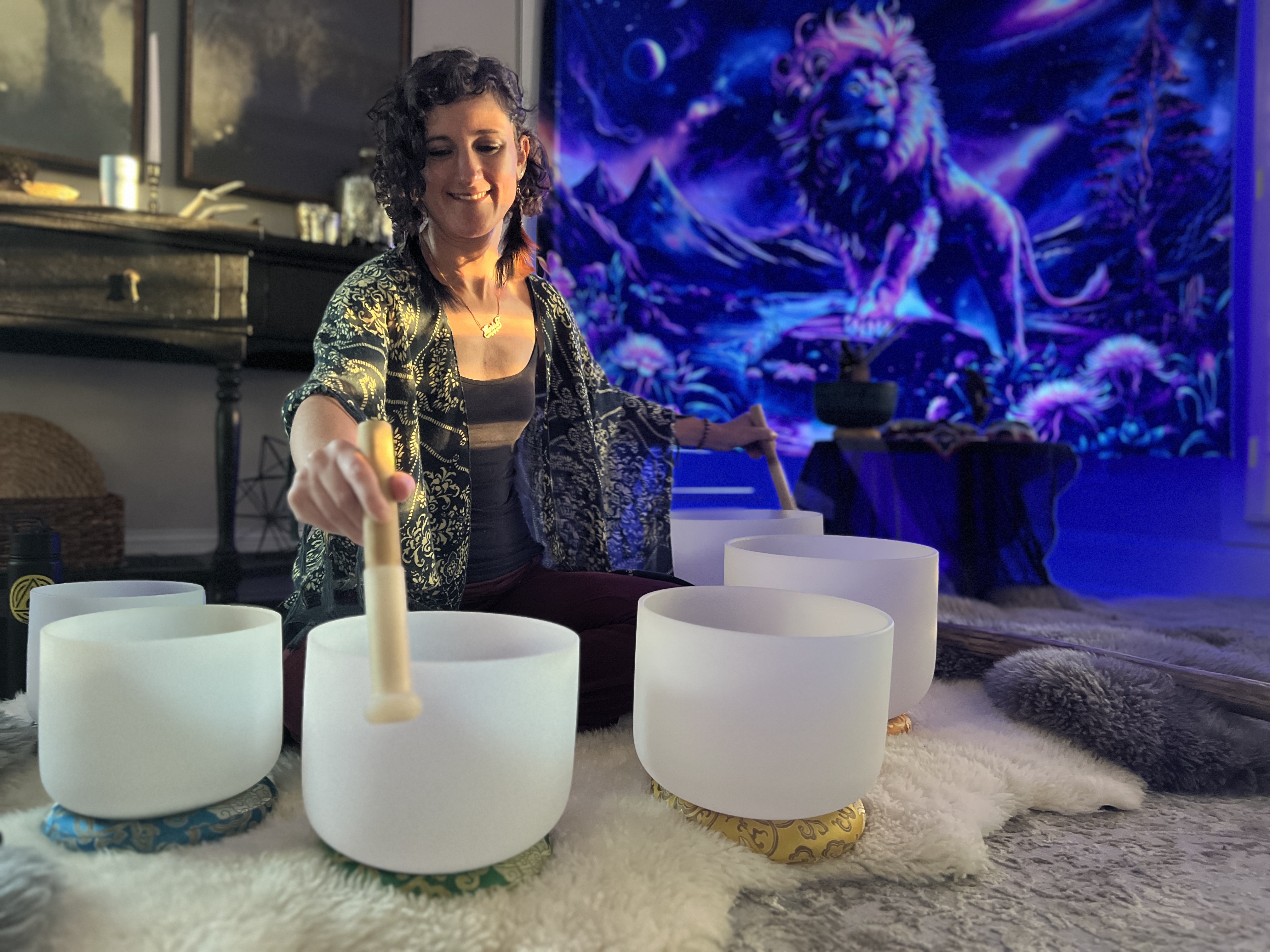 A serene indoor sound bath session with gongs and singing bowls — participants resting in deep relaxation