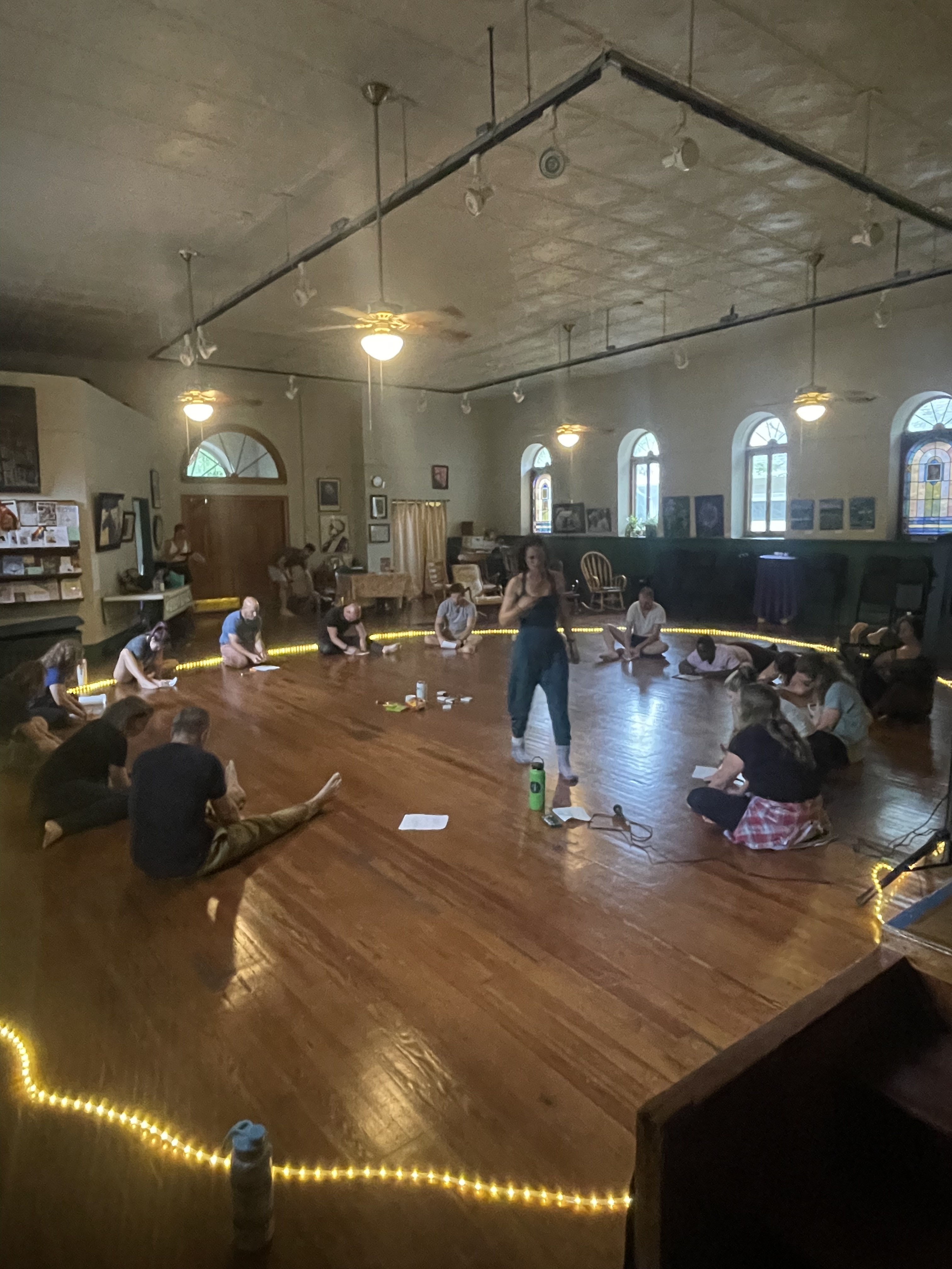 A calm, smiling multiethnic team sitting in lotus pose — relaxing together in a group wellness session
